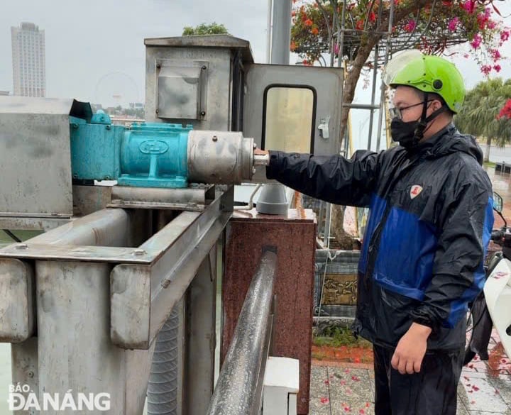 Công nhân Công ty Thoát nước và xử lý nước thải Đà Nẵng vận hành nâng các cửa phai để thoát nước mưa. Ảnh: H.H
