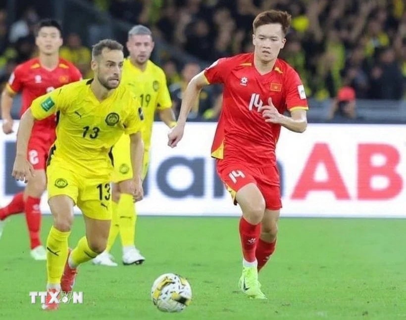 Dribble de Hoang Duc (14-Vietnam) face aux joueurs malaisiens. (Photo : VNA)