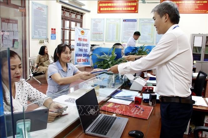 Công chức Bộ phận một cửa UBND phường Thọ Xương, thành phố Bắc Giang trả kết quả thủ tục hành chính cho người dân. Ảnh minh họa: Đồng Thúy/TTXVN