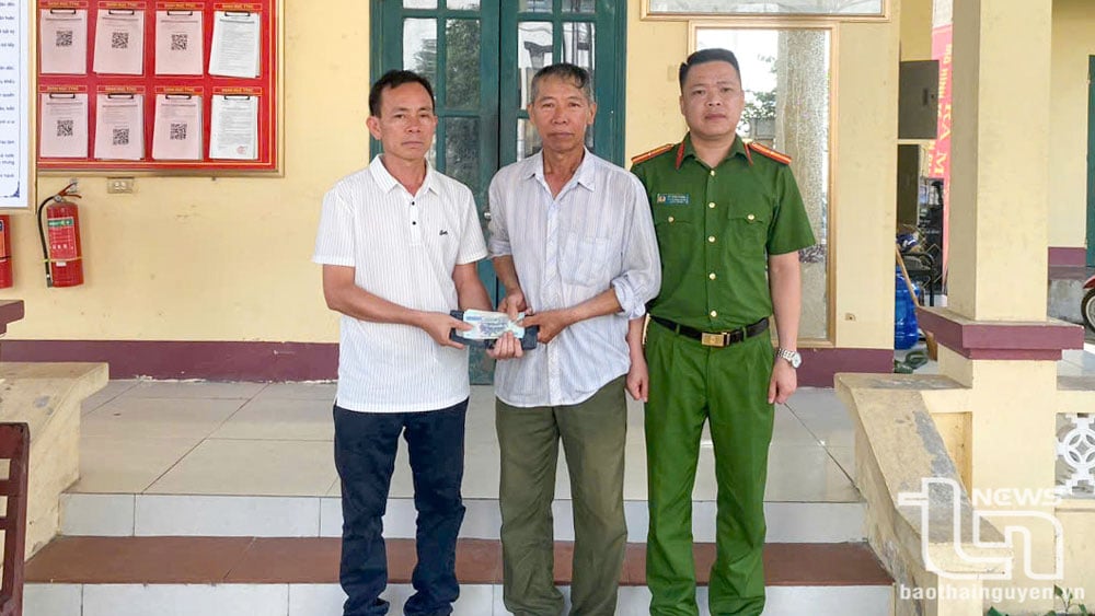 Ông Nguyễn Quang Hoà (người đầu tiên bên trái) trả lại gần 5 triệu đồng cho người đánh rơi, trước sự chứng kiến của Công an xã Cổ Lũng.