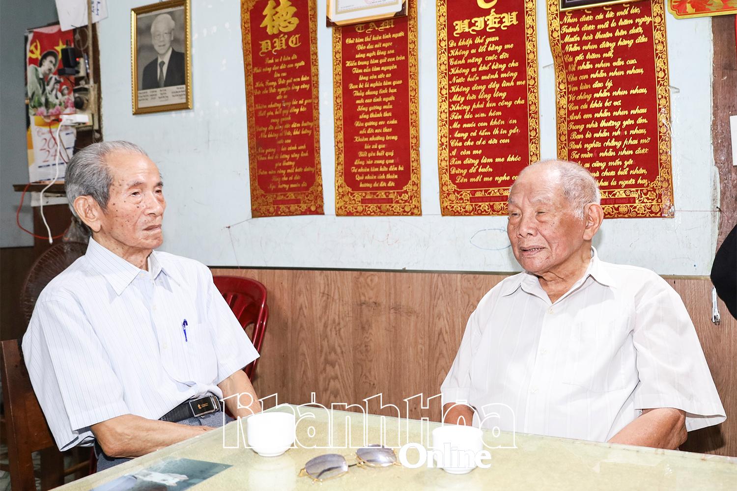 Mr. Duong Quang Sen (right) and Mr. Nguyen Dinh Tri recall memories of a time when they fought together.
