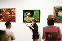 Phan Tu Tran erzählt von der Idee, das Bild von Doraemon auf der Ausstellung zu erschaffen. Foto: NVCC