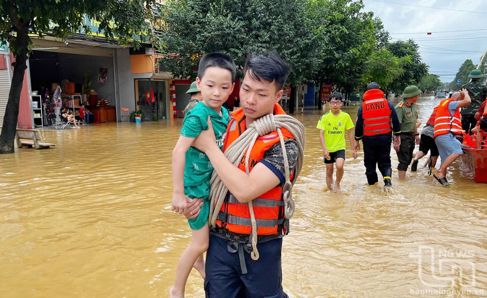 Des journalistes sont régulièrement présents sur les lieux sensibles afin de fournir des informations et des images authentiques sur les inondations. Des agents de la police provinciale aident les habitants du quartier de Quang Vinh (ville de Thai Nguyen) à évacuer les zones inondées lors des inondations de septembre dernier. Photo : T.L.