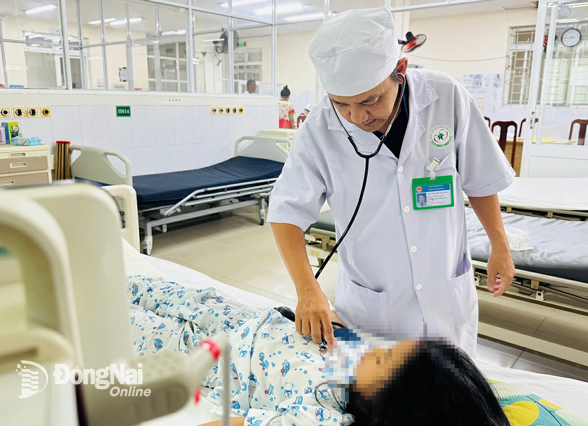 Un médecin examine un enfant atteint de dengue et soigné à l'hôpital pédiatrique de Dong Nai. Photo : H. Dung