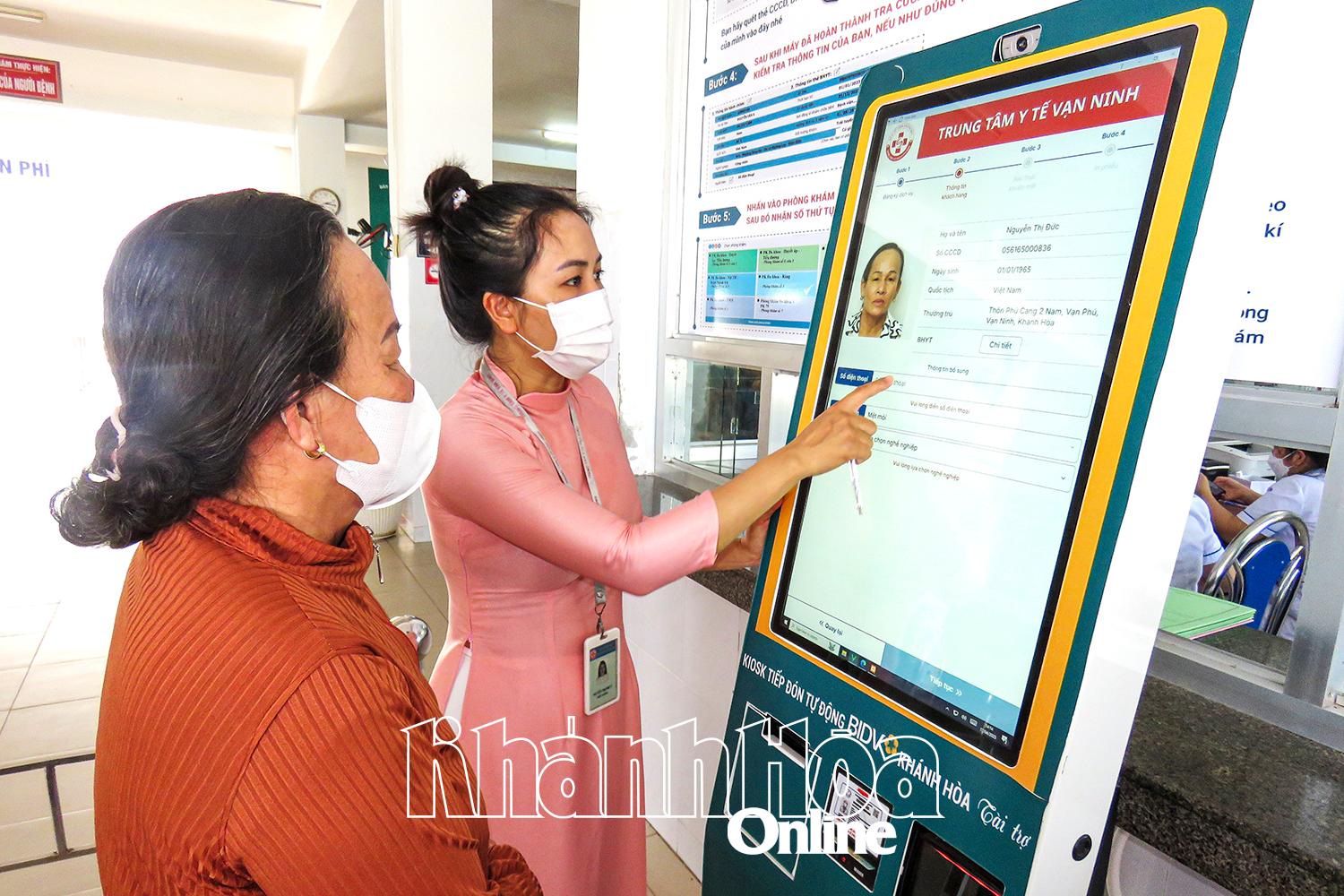 បុគ្គលិកនៃមជ្ឈមណ្ឌលវេជ្ជសាស្ត្រស្រុក Van Ninh ណែនាំលោកស្រី Nguyen Thi Duc ធ្វើនីតិវិធីពិនិត្យសុខភាពនៅបញ្ជរពេទ្យឆ្លាតវៃ។
