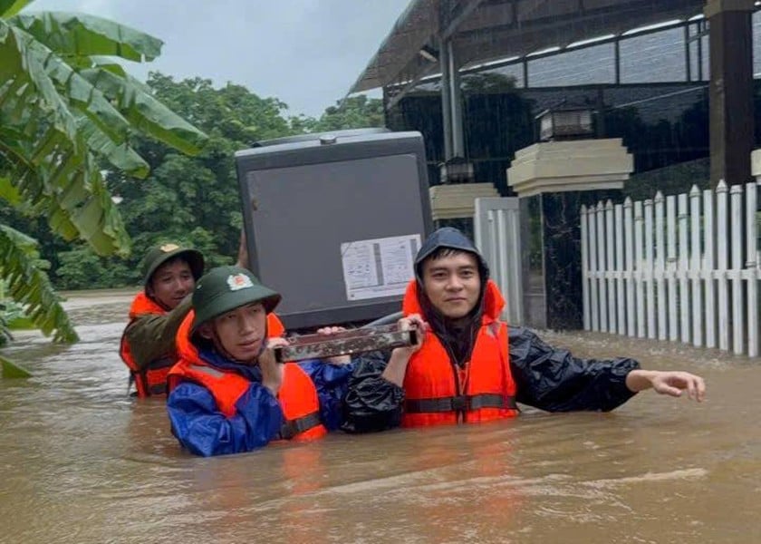 Lực lượng công an sơ tán đồ đạc giúp dân thị trấn Lao Bảo, huyện Hướng Hóa (Quảng Trị) do mưa lũ của bão số 1 gây ngập sâu. Ảnh: CA Quảng Trị