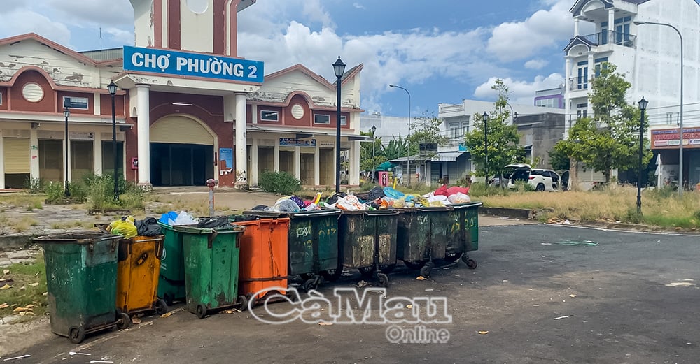 Những thùng rác trước cửa chợ Phường 2 đã 3 ngày chưa được thu gom