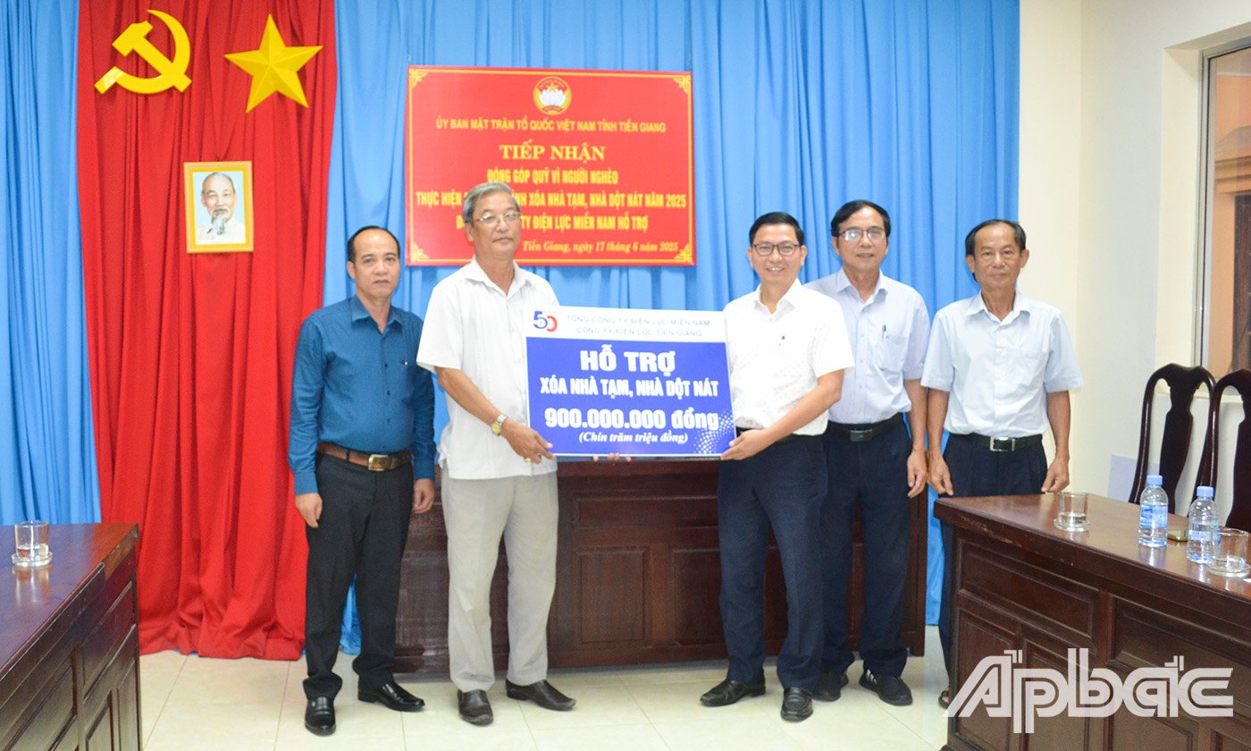 Đại diện đơn vị tài trợ ông Trần Quang Tâm (bên phải ảnh), Phó Giám đốc Công ty Điện lực Tiền Giang trao Bảng tượng trưng 900 triệu đồng cho Ủy Ban MTTQ Việt Nam tỉnh Tiền Giang.