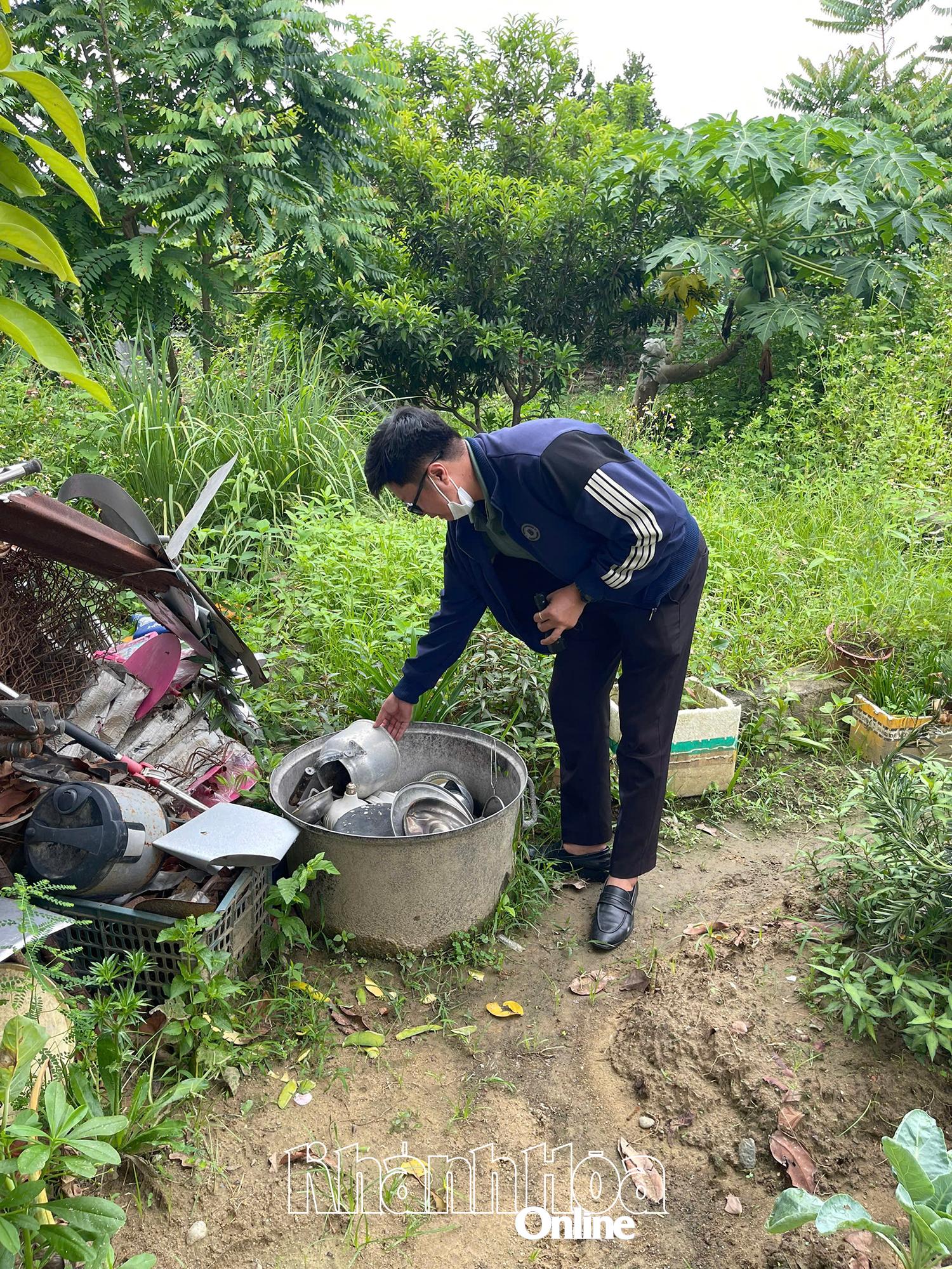 Cán bộ y tế huyện DIên Khánh kiểm tra và úp các vật dụng chứa nước bỏ ngoài sân của hộ dân.