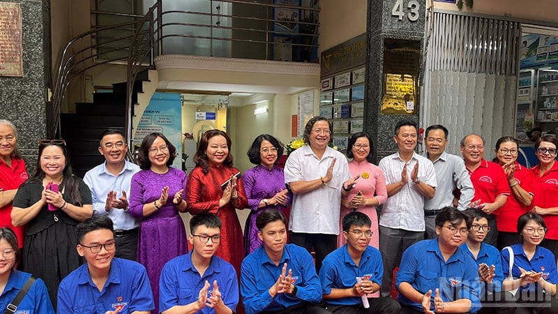 Delegates take souvenir photos at the former headquarters of Dan Chung Newspaper. (Photo: Manh Hao)