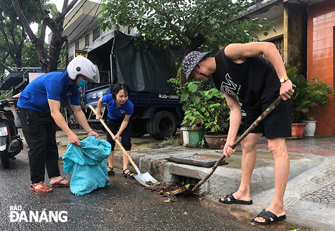 Người dân trên địa bàn quận Liên Chiểu tập trung khơi thông cống rãnh trước mùa mưa bão năm nay. Ảnh: HUỲNH LÊ