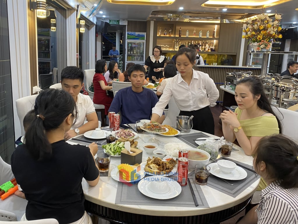 អ្នកទេសចរទទួលទានអាហារពេលល្ងាចនៅលើទូកភោជនីយដ្ឋាននៅ Cruise Night Street កំពង់ផែអ្នកដំណើរអន្តរជាតិ Tuan Chau ។