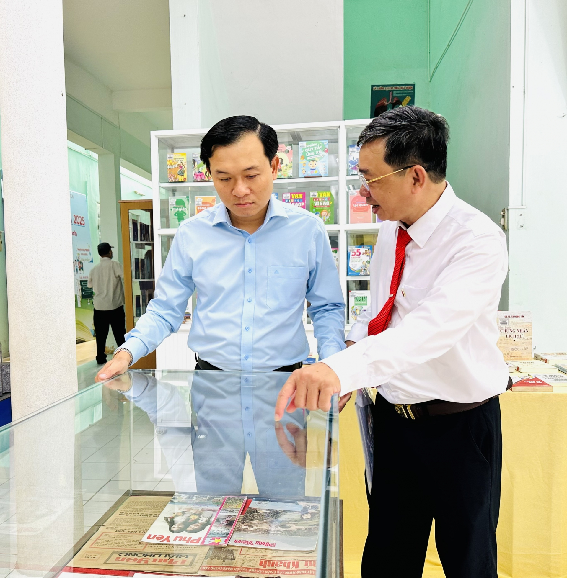 Đồng chí Bùi Thanh Toàn và nhà báo Phạm Đoàn Anh Kiệt trao đổi về một hiện vật. Ảnh: YÊN LAN