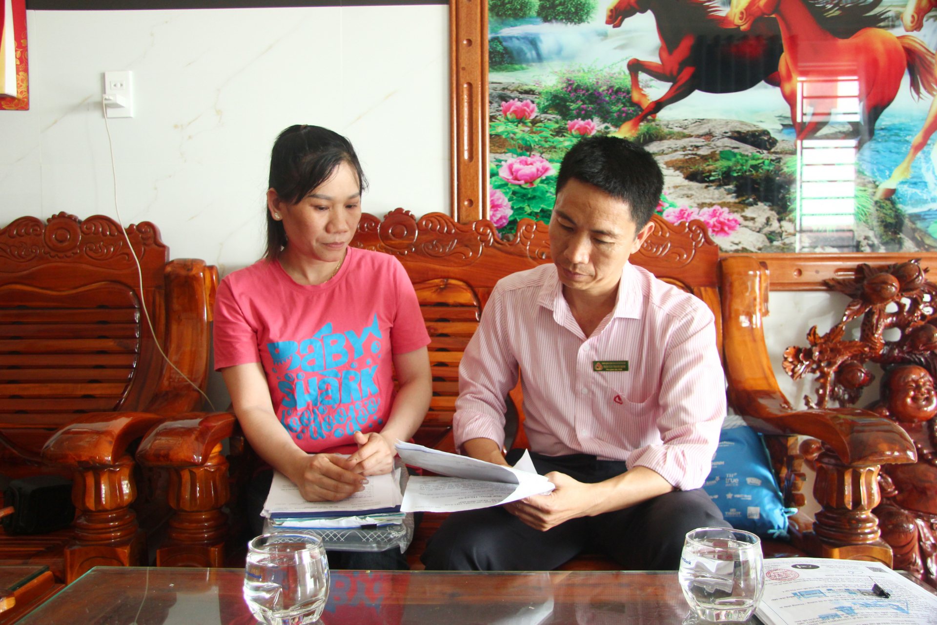 Cán bộ NHCSXH trao đổi với hộ vay ở thị trấn Hai Riêng (huyện Sông Hinh) về chương trình cho vay nhà ở xã hội. Ảnh: LÊ HẢO