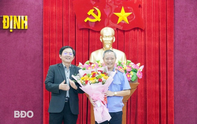 Bí thư Tỉnh ủy Bình Định Hồ Quốc Dũng trao quyết định, tặng hoa chúc mừng ông Lê Trung Hưng. Ảnh: Báo Bình Định