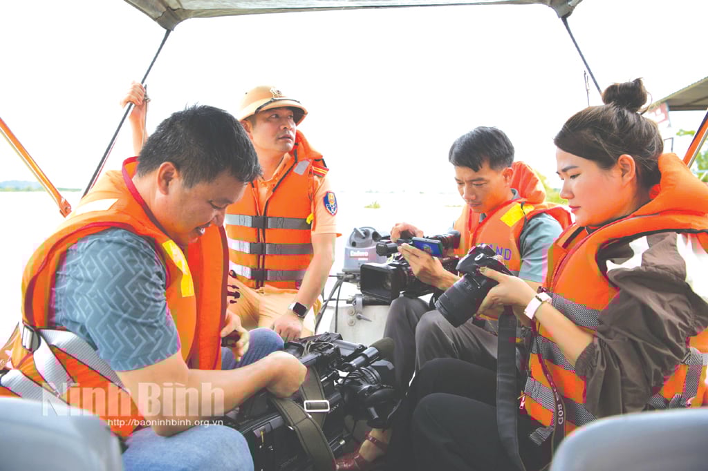 Reporter der Zeitung Ninh Binh, des Radio- und Fernsehsenders der Provinz und der vietnamesischen Nachrichtenagentur bereiten sich auf ihre Arbeit während des Taifuns Yagi im September 2024 vor. Foto: Truong Giang