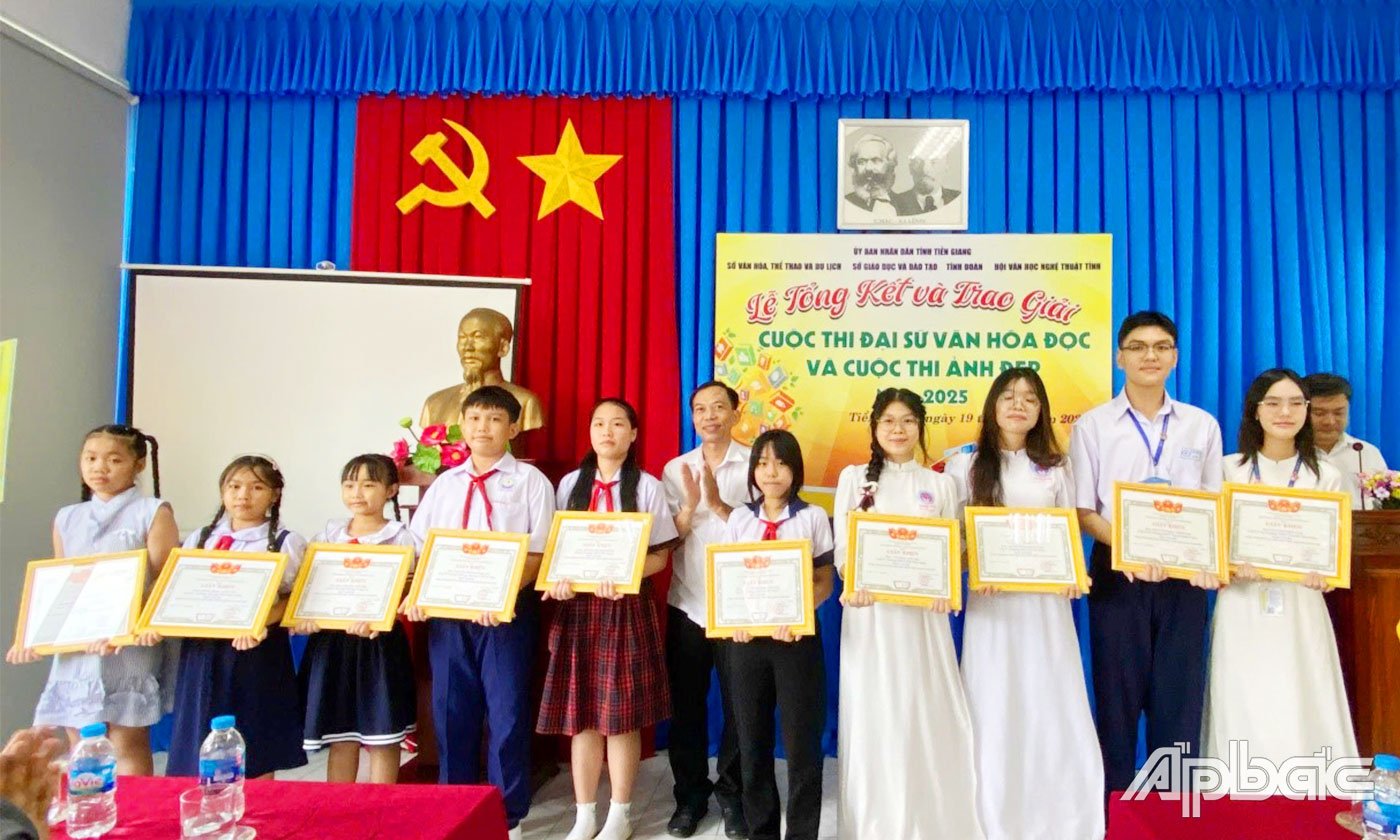 Giám đốc Thư viện tỉnh Võ Nam Phước trao giải cho các em đoạt giải.
