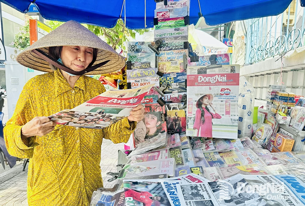 Mme Thu Huong (74 ans), propriétaire d'un kiosque à journaux existant depuis un demi-siècle à travers deux générations à Ho Chi Minh Ville.