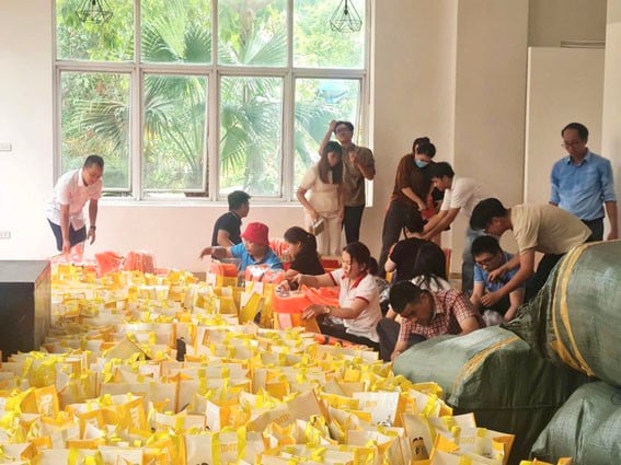 Đội ngũ nhà báo, phóng viên, người lao động Báo Pháp luật Việt Nam đóng gói từng phần quà gửi đến đồng bào vùng lũ. (Ảnh: Lê Hanh)