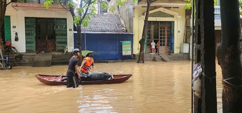 Đường vào trụ sở UBND phường Quang Vĩnh (cũ) ngập sâu, người dân hỗ trợ nhau đưa phương tiện ra khỏi khu vực ngập.