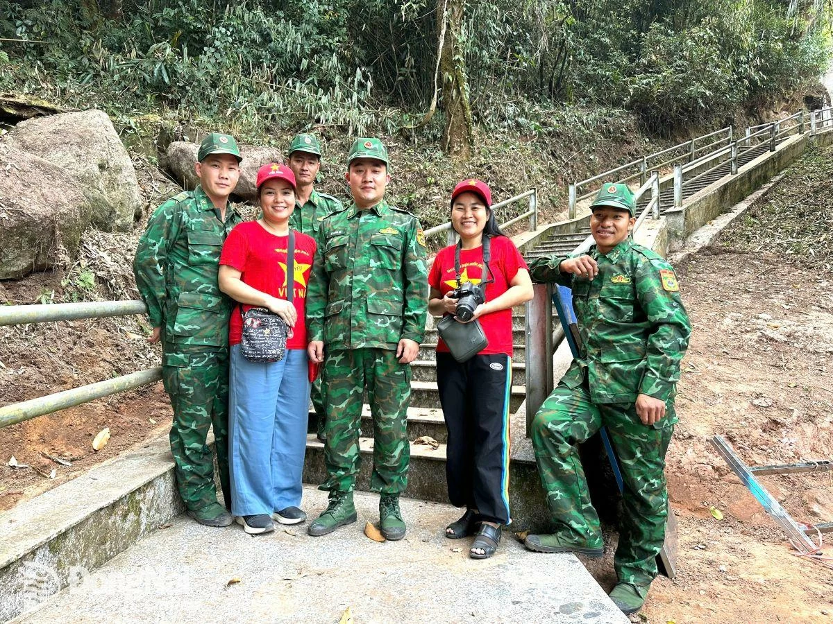 Los reporteros del periódico Dong Nai tomaron fotos de recuerdo con los guardias fronterizos antes de subir los últimos 500 escalones hasta el marcador fronterizo más occidental en la cima de la montaña Khoan La San.