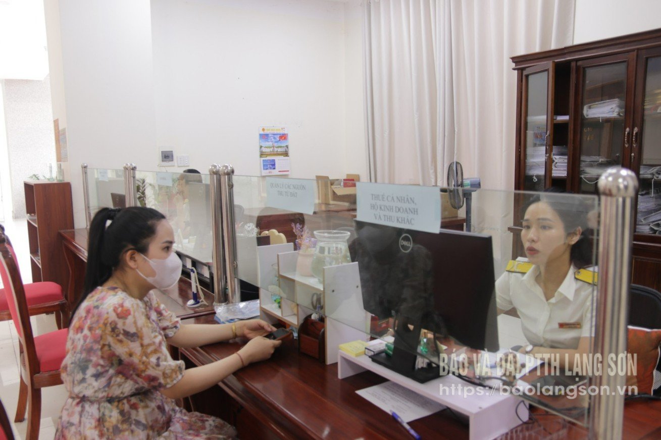 Cán bộ thuế bộ phận một cửa Chi cục Thuế khu vực VI hướng dẫn người nộp thuế một số chính sách mới 