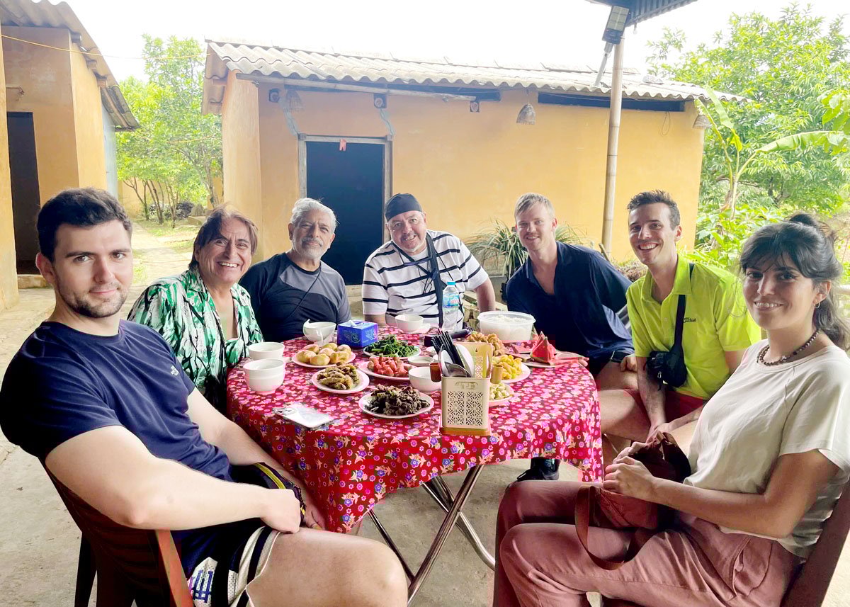 Du khách quốc tế trải nghiệm bữa cơm truyền thống tại homestay của gia đình anh Lý Tà Sàng, thôn Nặm Đăm (Quản Bạ).