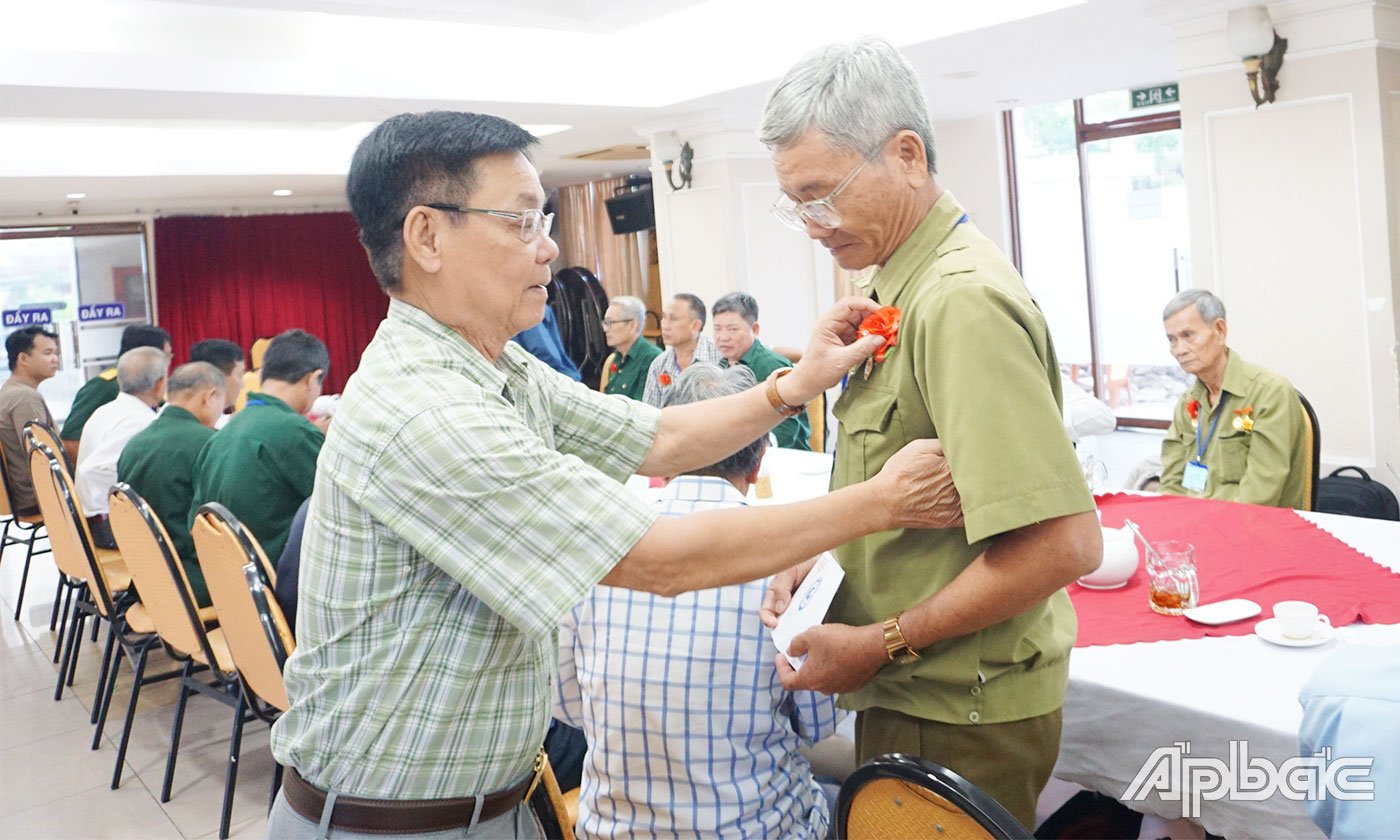 Cài hoa và tặng quà cho các cựu chiến binh tham quan Nhà tù Côn Đảo. 