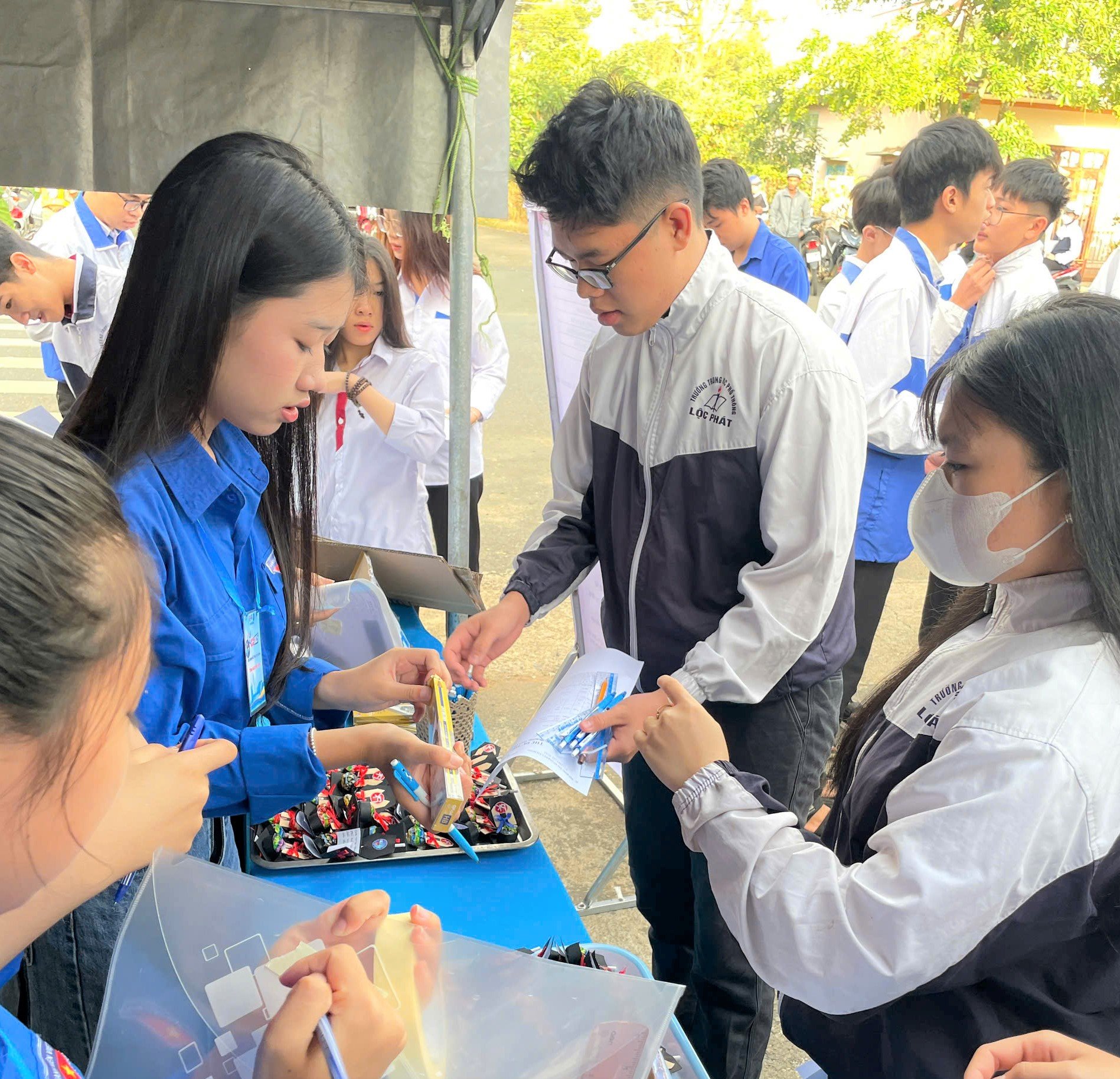 Thanh niên tình nguyện tại các điểm thi trên địa bàn TP Bảo Lộc phát thước, bút miễn phí tiếp sức cho thí sinh