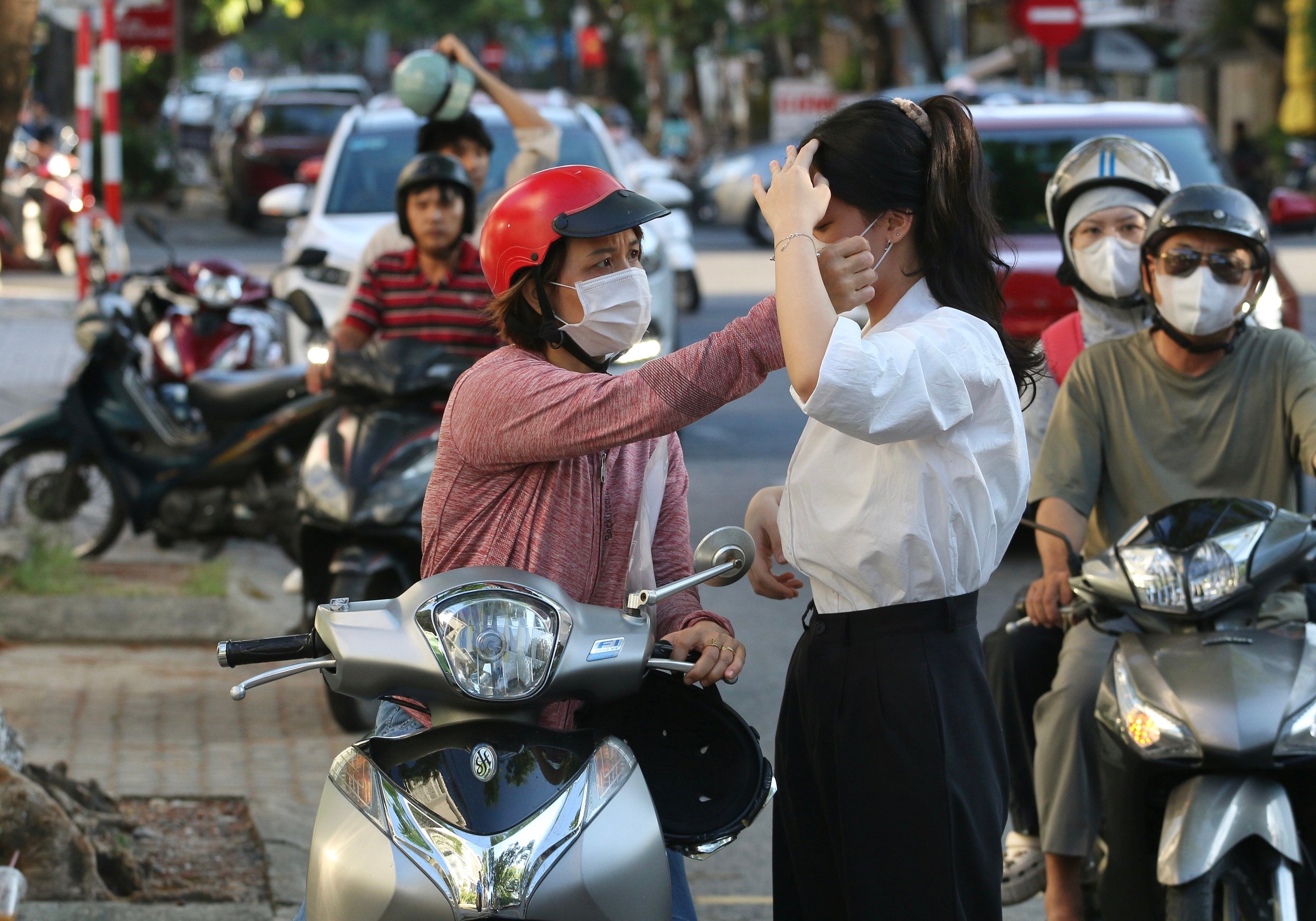 Phụ huynh 'đứng ngồi không yên' ở vỉa hè chờ con thi tốt nghiệp THPT- Ảnh 1.