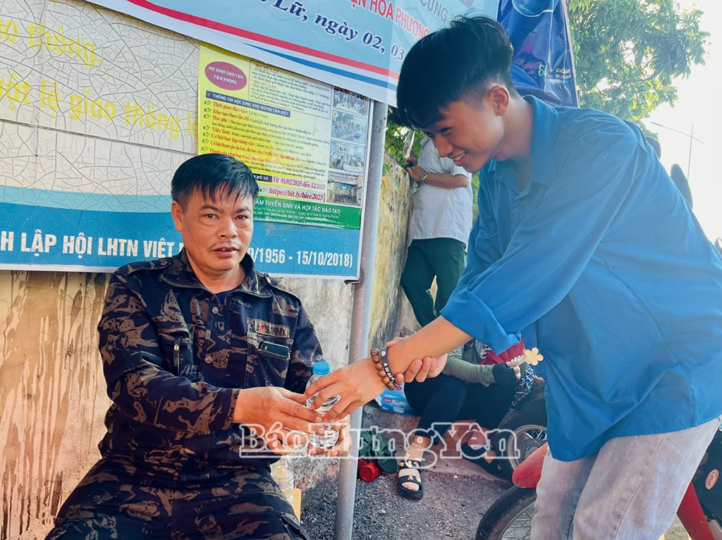 Tình nguyện viên phát nước tặng người nhà thí sinh đợi ngoài khu vực thi  (Ảnh chụp tại điểm thi THPT Tiên Lữ)