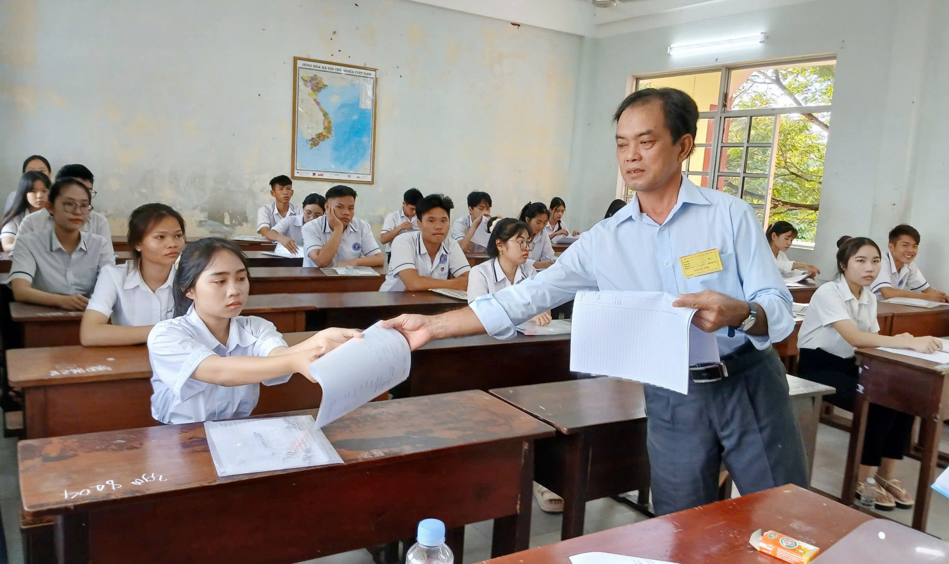 El supervisor distribuye los exámenes y las pruebas antes de entregar el examen de Literatura. Foto: TRUNG HIEU