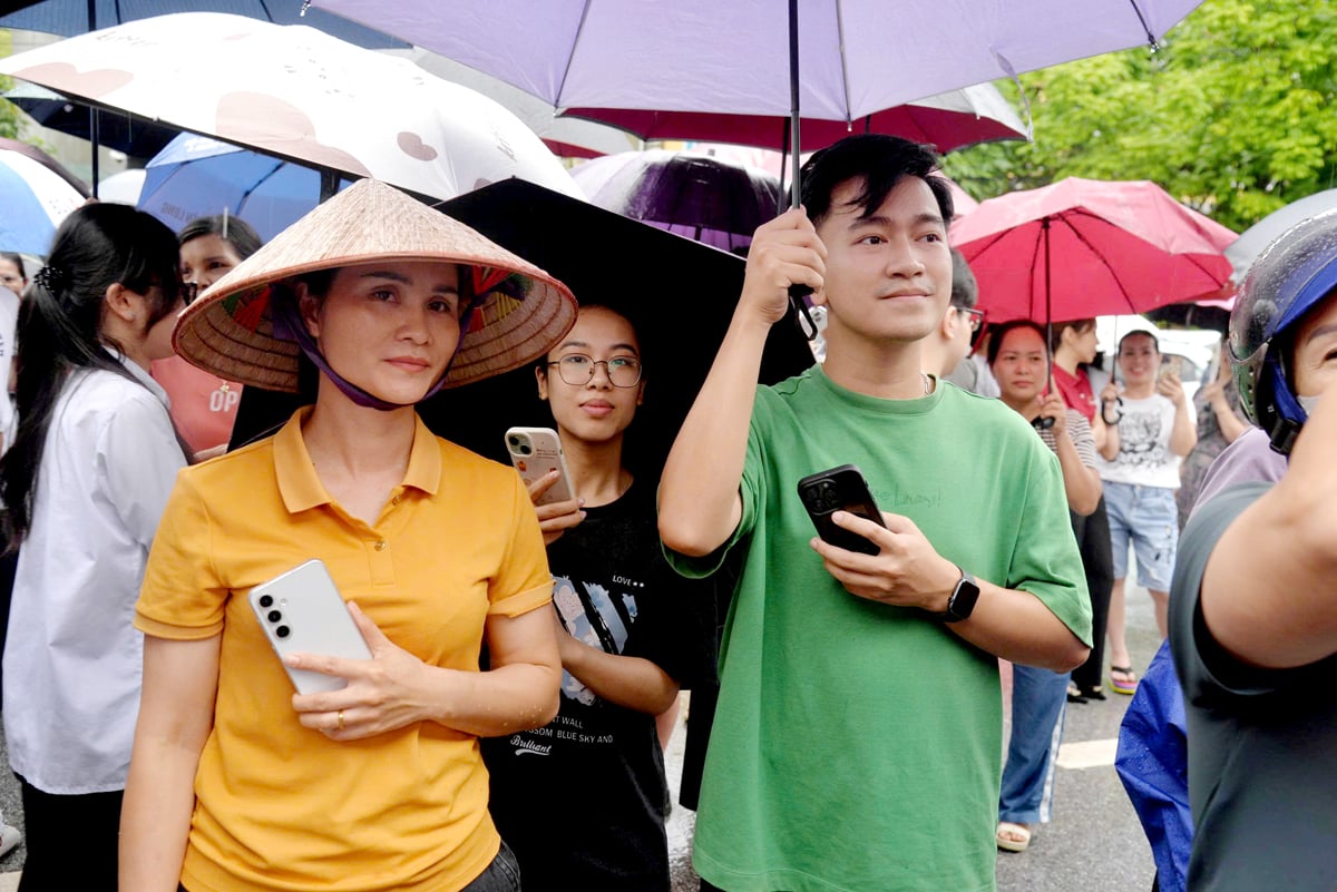Phụ huynh đội mưa chờ con kết thúc kỳ thi.
