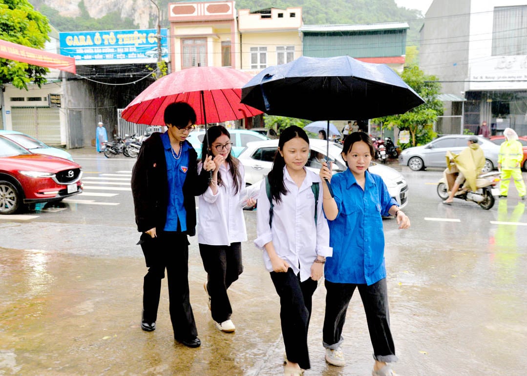 Despite the rain, the youth union members and volunteers enthusiastically supported the candidates at the exam site. (Photo: Moc Lan)