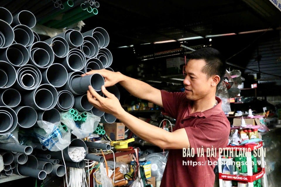 Mr. Toan arranges goods in his family business store.