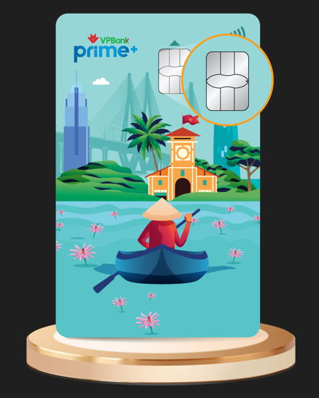 A vertical illustration of a VPBank Prime+ debit card design, showcasing a vibrant Vietnamese landscape. The design features a person in a conical hat paddling a boat among pink lotus flowers on water, with a traditional yellow-orange building and modern city skyline including a bridge in the background. The card also displays a prominent chip (magnified in a circle) and a contactless payment symbol at the top right, sitting on a golden cylindrical pedestal.