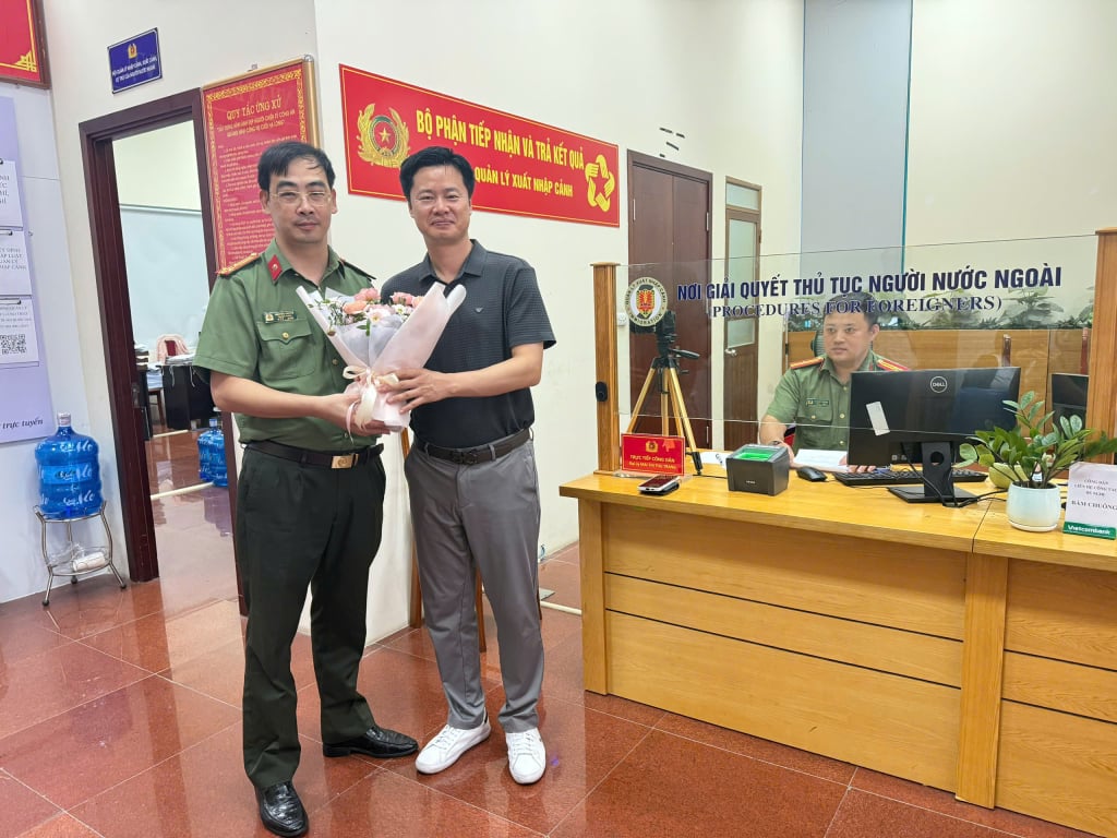Lãnh đạo Phòng Quản lý xuất nhập cảnh tặng hoa cho người nước ngoài đầu tiên được thu nhận hồ sơ định danh điện tử cấp độ 2.