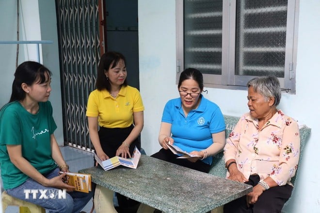Nhân viên Bảo hiểm xã hội tỉnh Trà Vinh phối hợp với các đơn vị vận động hộ gia đình tham gia bảo hiểm xã hội tự nguyện và bảo hiểm y tế. (Ảnh: Thanh Hòa/TTXVN)