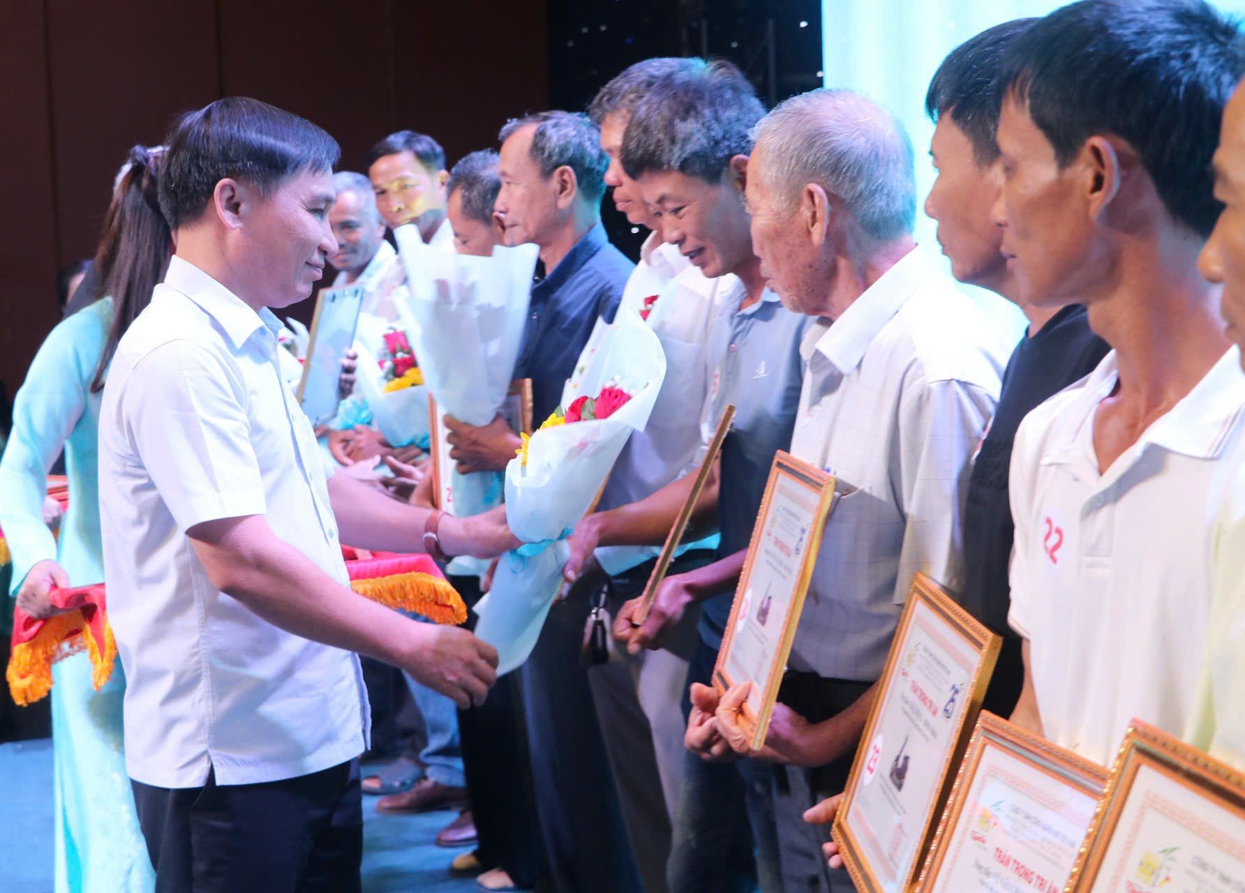 Ông Nguyễn Quốc Hoàn, Ủy viên Ban Thường vụ Tỉnh ủy, Trưởng ban Tổ chức Tỉnh ủy trao hoa, bảng tri ân cho nông dân.