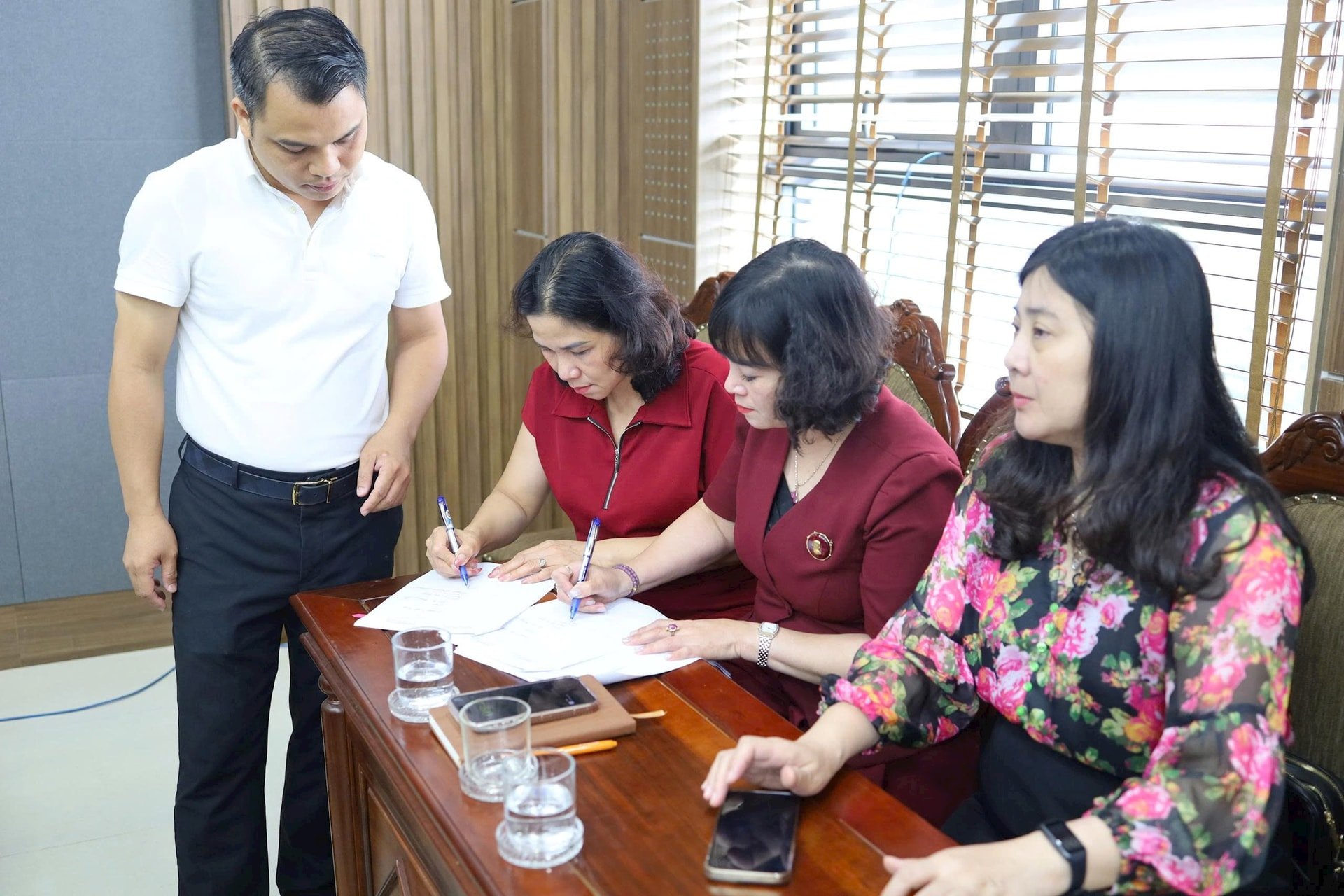 Cán bộ UBND quận Tây Hồ và UBND phường Xuân Đỉnh (mới) bàn giao tài liệu. Ảnh: Nguyên Anh