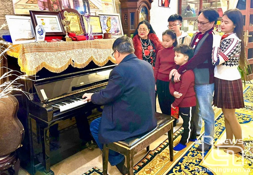 Ông Ngô Đình Thành chơi nhạc tại nhà trong sự cổ vũ của vợ và con cháu.