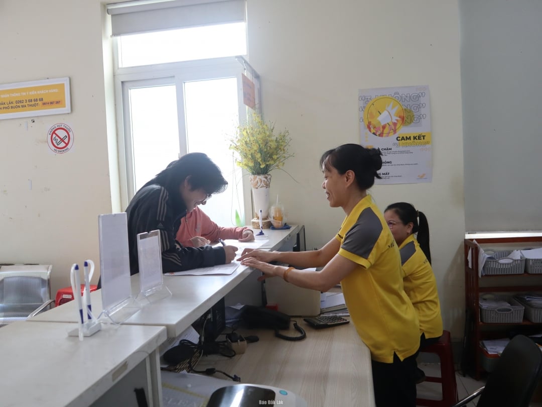 Nhân viên bưu điện hướng dẫn người dân ghi thông tin địa chỉ mới và cũ song song để thuận lợi cho việc chuyển phát trong giai đoạn đầu sáp nhập.