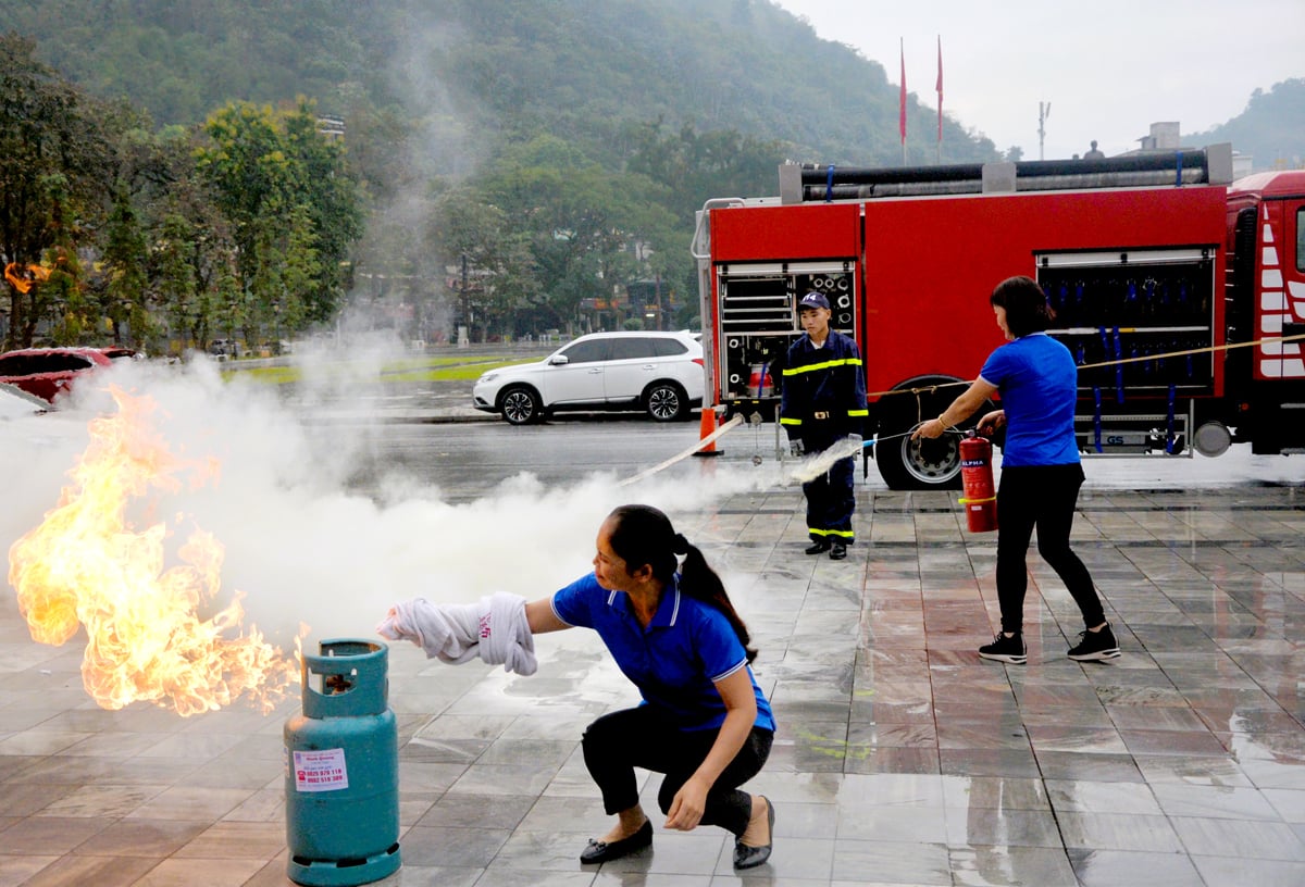 Oficiales y empleados de Ha Giang Printing Joint Stock Company practican la extinción de un incendio en un cilindro de gas.