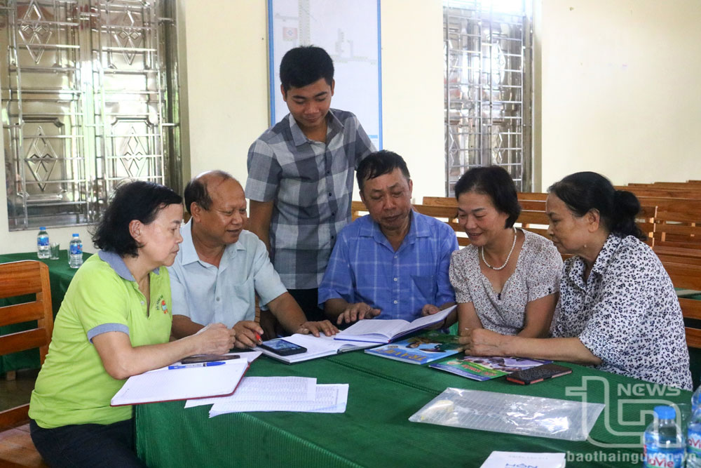 Miembros del Comité de Trabajo del Frente de la aldea de Bo Dau, comuna de Co Lung (Phu Luong) comparten experiencias en la preservación del calor familiar.