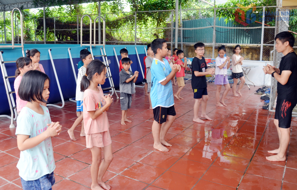 Swimming instructors guide students in class through warm-up exercises before learning swimming skills in the pool.