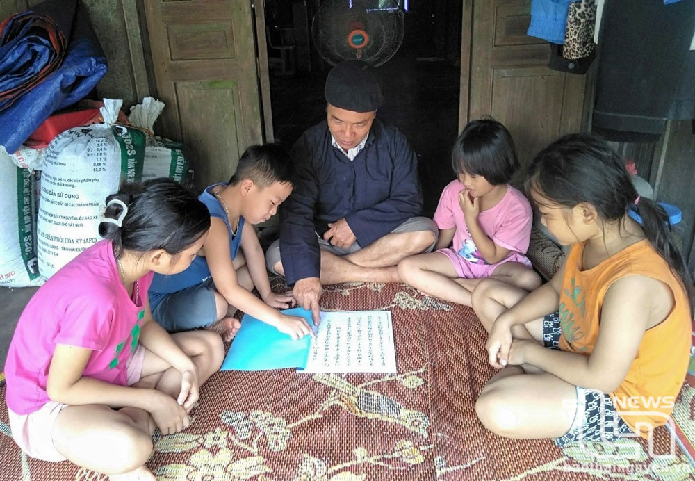 El Sr. Chu Van Cam, de la aldea Dong Luong, comuna de Tan Long (Dong Hy), guía a los niños para que lean y hablen su idioma étnico.