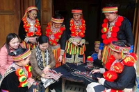Dao ethnic women in Ban Cuon village, Ngoc Phai commune, Cho Don district introduce products to tourists. (Photo by HUONG LIEU)