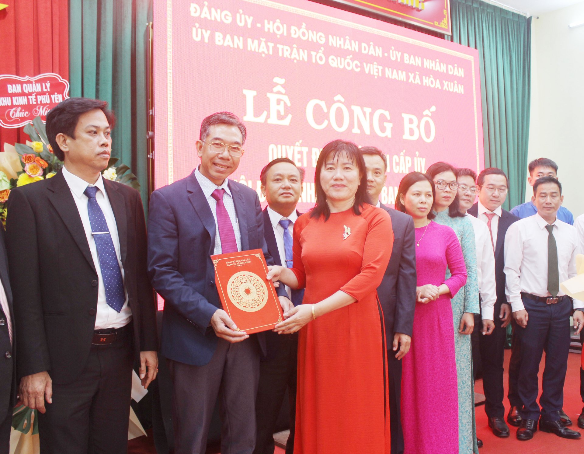 Bà Đào Thị Mỹ Dung, Phó Giám đốc Sở Tư pháp trao quyết định và tặng hoa chúc mừng BCH Đảng bộ xã Hòa Xuân. Ảnh: VĂN TÀI