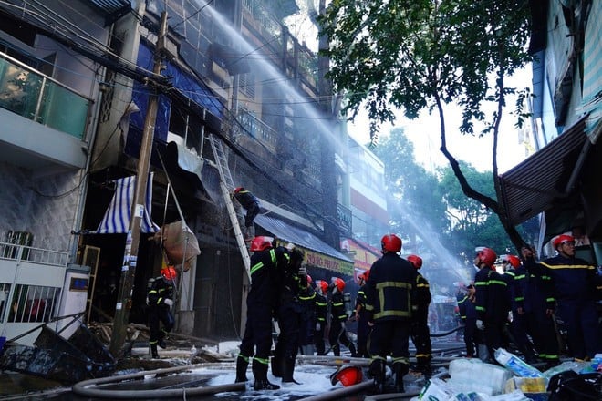 Lực lượng Cảnh sát phòng cháy chữa cháy triển khai đội hình dập lửa. (Ảnh: TTXVN phát)
