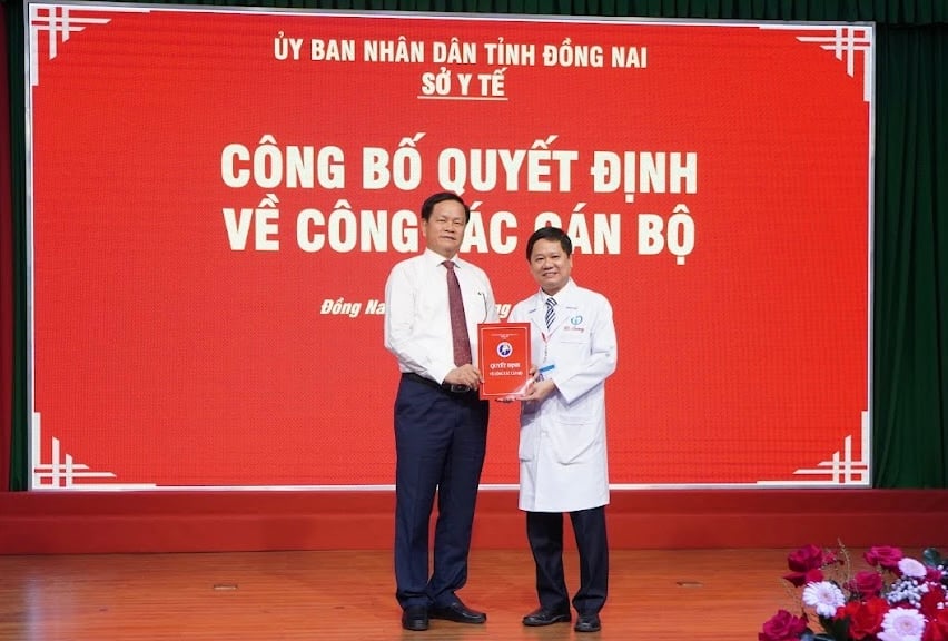 Phó giám đốc Sở Y tế Nguyễn Văn Bình trao quyết định cho bác sĩ chuyên khoa II Nguyễn Tường Quang. Ảnh: Q.T